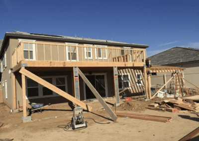 A house under construction with a wooden deck.