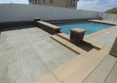 A backyard with a pool and a fence.