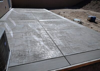 A concrete patio is being laid out in a backyard.