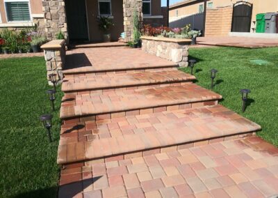 A brick patio with steps leading up to a house.