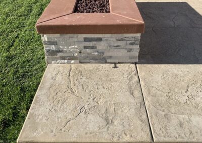 A concrete fire pit in a backyard.