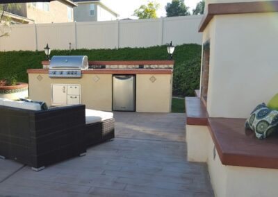 A backyard with a grill and patio furniture.